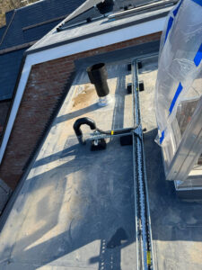 Cable tray carrying solar cabling across the flat membrane roof of a care home in York
