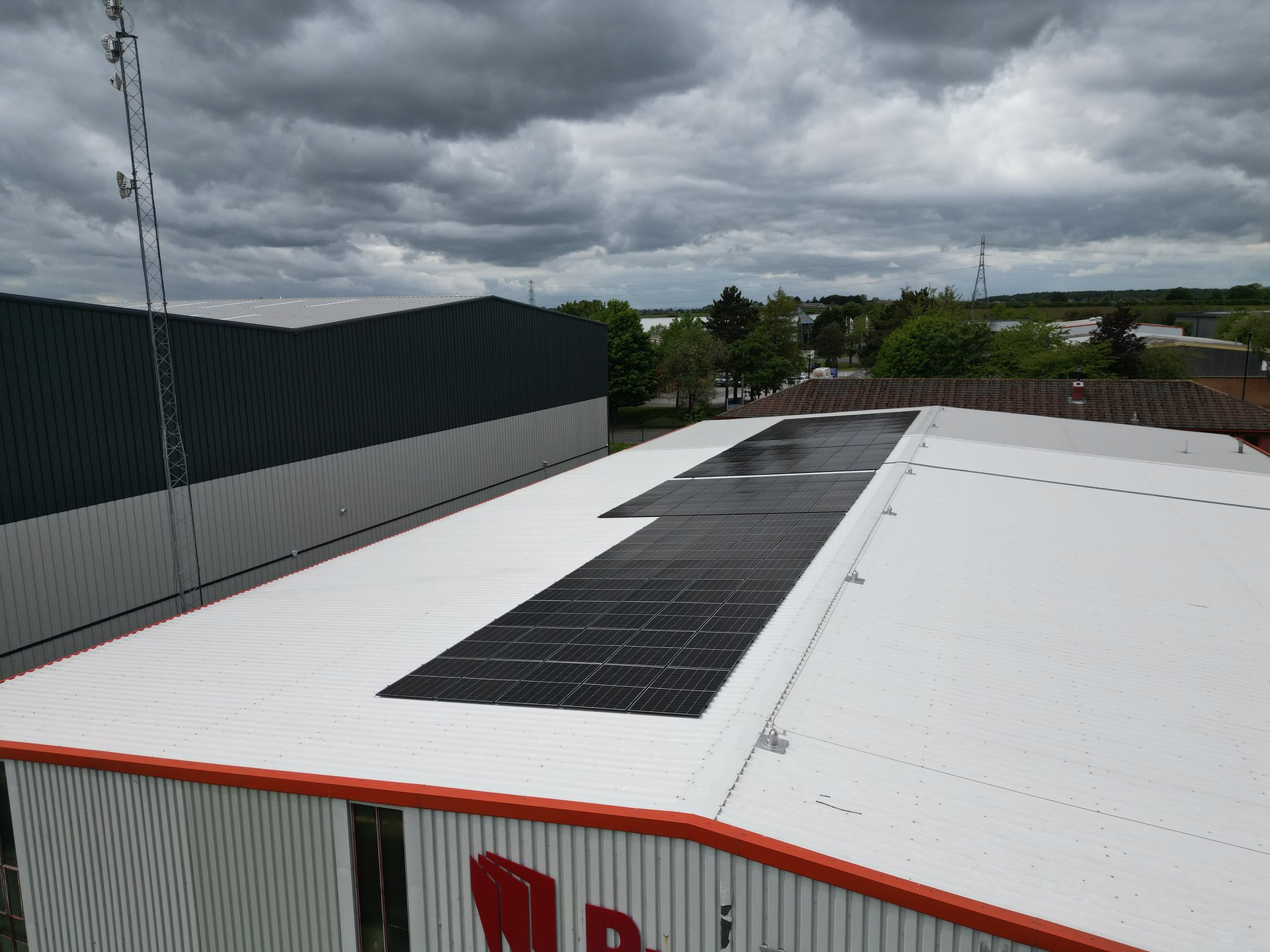 All-black solar panels on the white insulated roof of a manufacturing building in Rotherham
